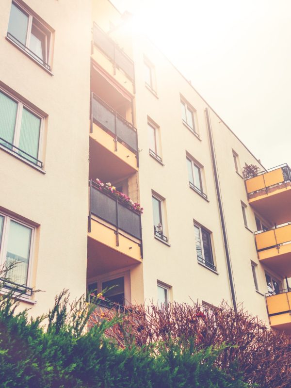 white-apartment-complex-with-yellow-balcony-and-su-2026-01-09-13-02-38-utc